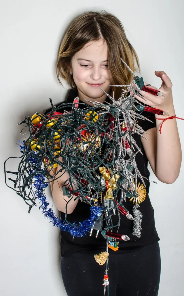 Child holding tangled Christmas lights